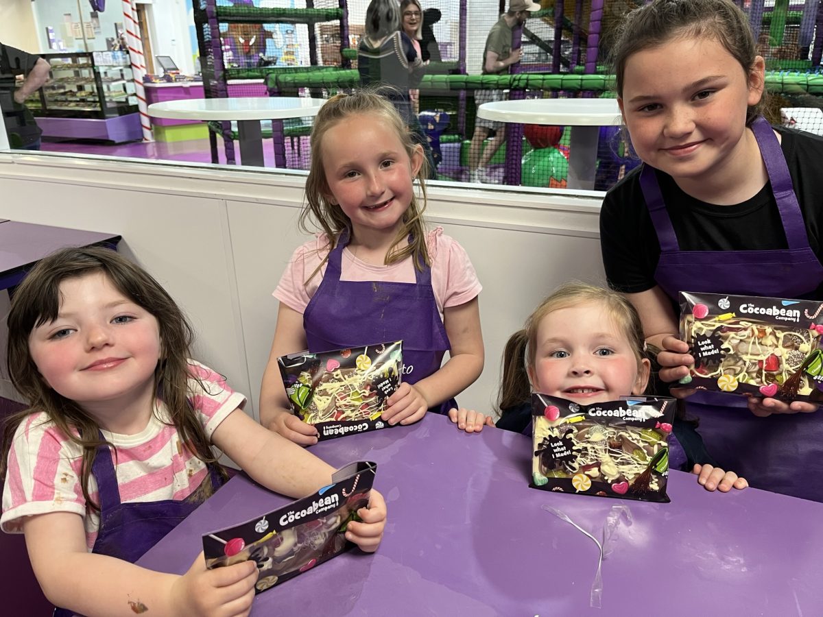 4 children in a chocolate workshop, purple table, chocolate bars